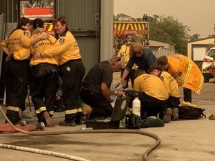 The unnamed firefighter is helped by colleagues after he was felled by heat exhaustion. Picture: Jack Morphet