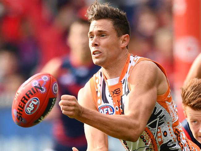 MELBOURNE, AUSTRALIA - MAY 26: Josh Kelly of the Giants handballs whilst being tackled by Oskar Baker of the Demons during the round 10 AFL match between the Melbourne Demons and the Greater Western Sydney Giants at Melbourne Cricket Ground on May 26, 2019 in Melbourne, Australia. (Photo by Quinn Rooney/Getty Images)