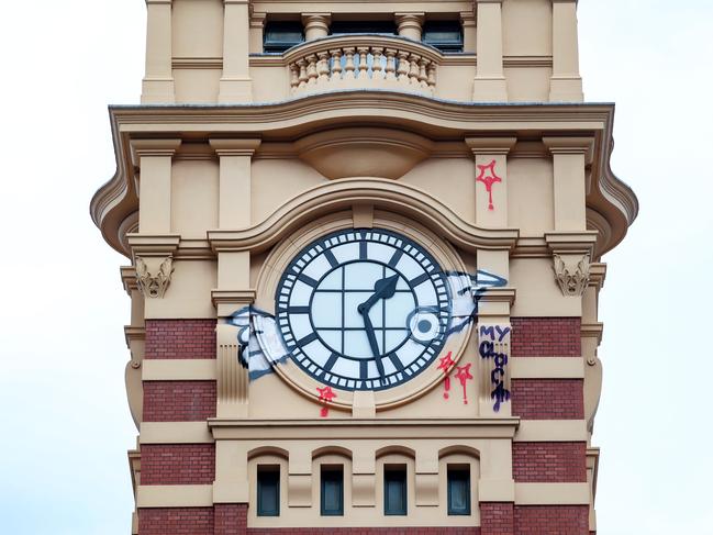 Graffiti covers one of the Flinders Street station clocks. Picture: Ian Currie