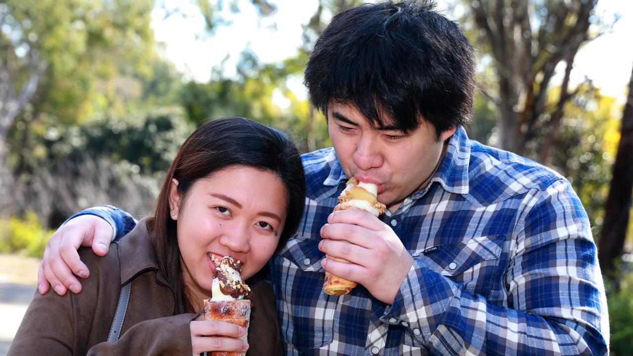 Aina Bautista and James Wong pose for photographs at the Cherry Blossom Festival in Auburn. (AAP IMAGE / Angelo Velardo)