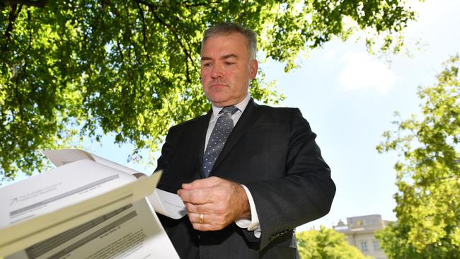 SA Health Minister Stephen Wade inspects an accreditation report on the RAH on March 23, 2018. AAP Image/David Mariuz.