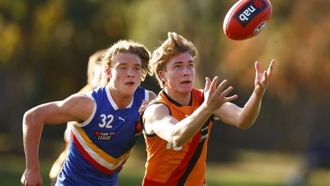 Jack Brown keeps his eye on the ball to mark in front of Cody Anderson.