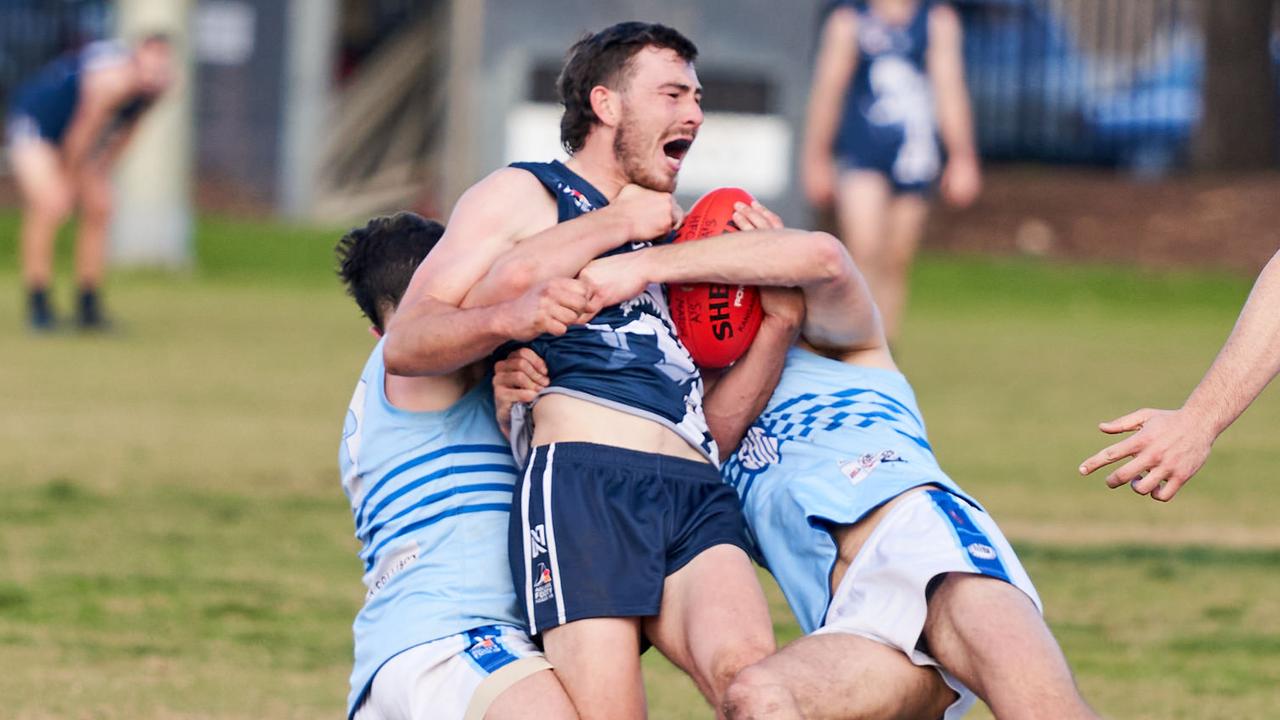 HenleyÃs Christopher Schwarz getÃs taken down by Sacred Heart Old CollegiansÃ Patrick Neal-Bullen and Jack Sires in Henley Beach, Saturday, July 11, 2020. Picture: MATT LOXTON