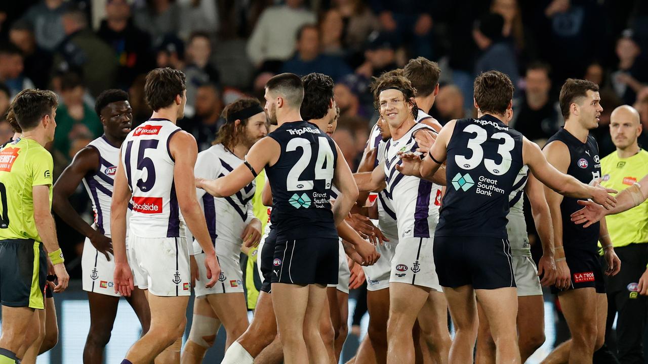 Dockers and Blues wrestle at three-quarter-time during a willing contest.