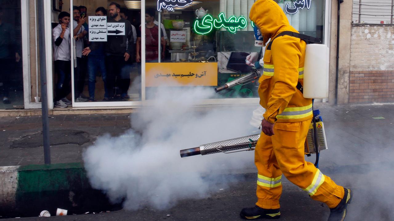 An Iranian firefighter disinfects a street in the capital Tehran in a bid to halt the wild spread of coronavirus. Picture: AFP