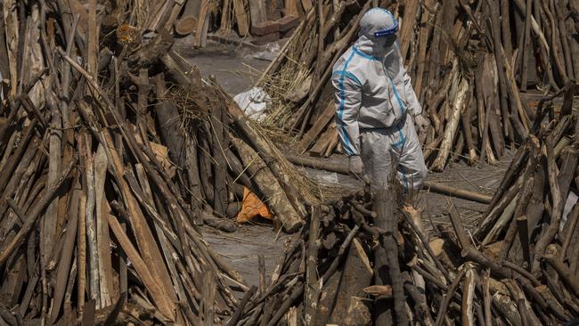 A health worker walks among funeral pyres before they were lit to perform the last ritesfor coronavirus patients in New Delhi. Picture: Getty Images