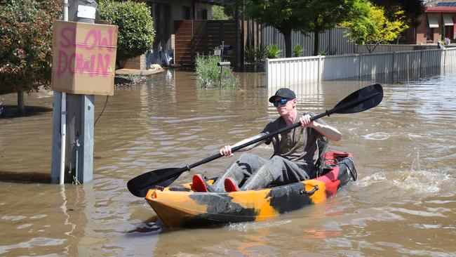 Brett McInnes paddles down Guthrie St, Shepparton after his home flooded. Picture: David Crosling