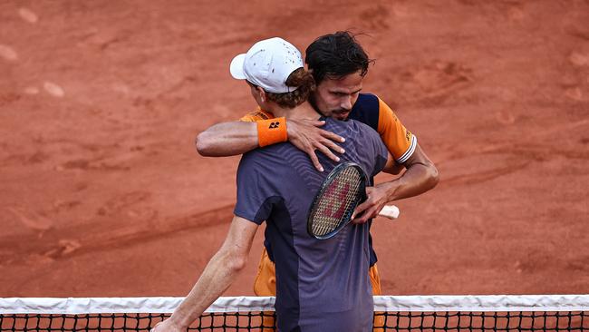 Germany's Daniel Altmaier embraces Jannik Sinner at the net. Photo by Anne-Christine POUJOULAT / AFP.