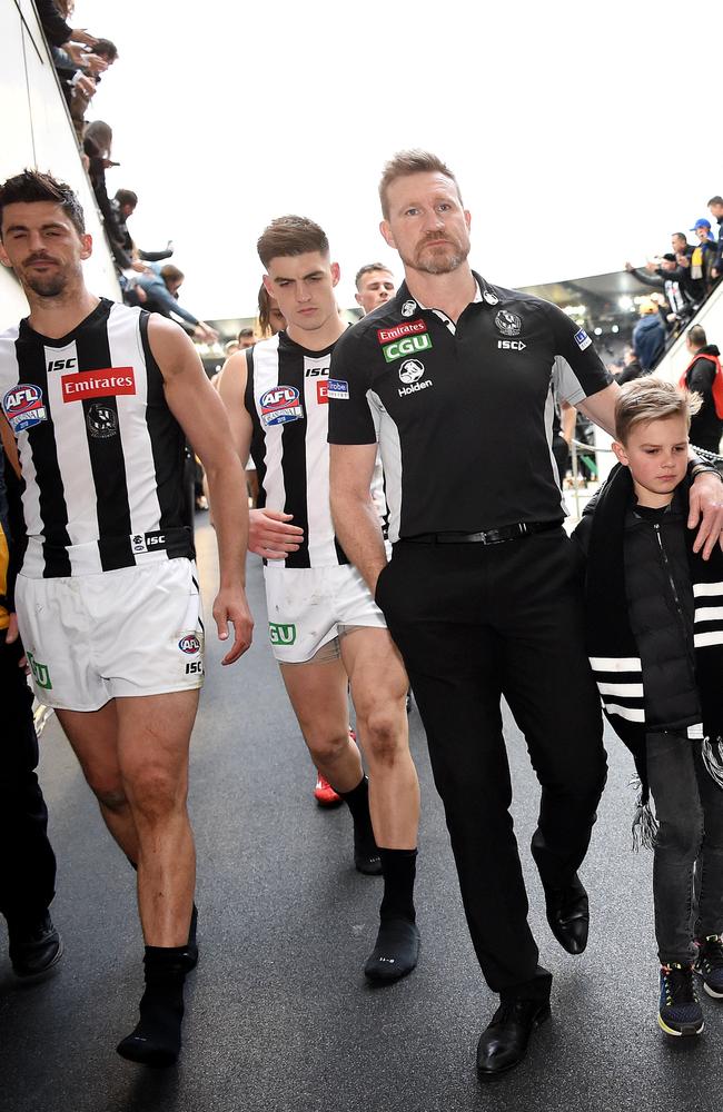 Collingwood coach Nathan Buckley leaves the field with his son. Picture: Nicole Garmston