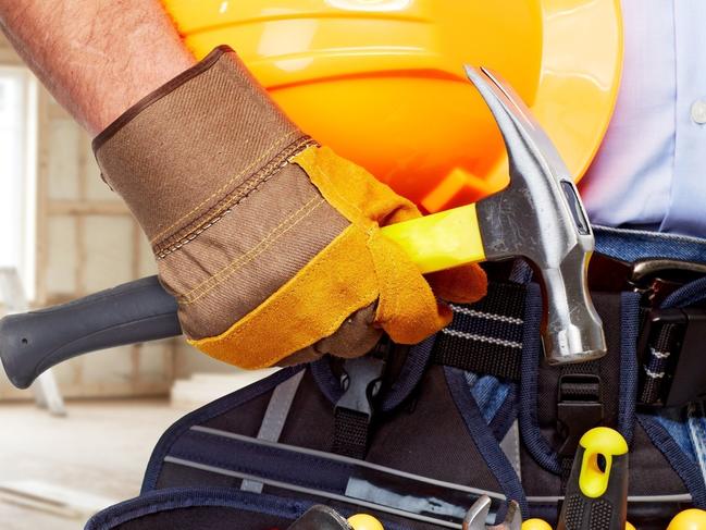 Builder handyman with construction tools. House renovation background.