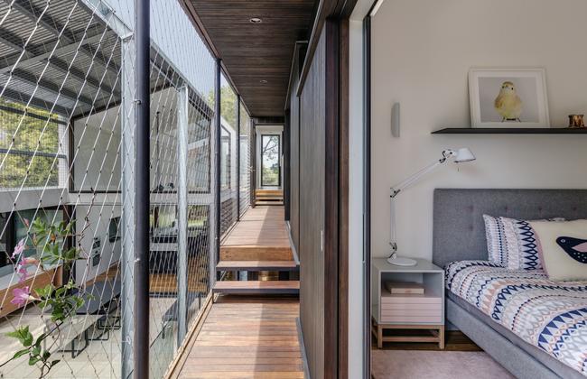 A covered outdoor corridor connects the kids’ bedrooms upstairs.