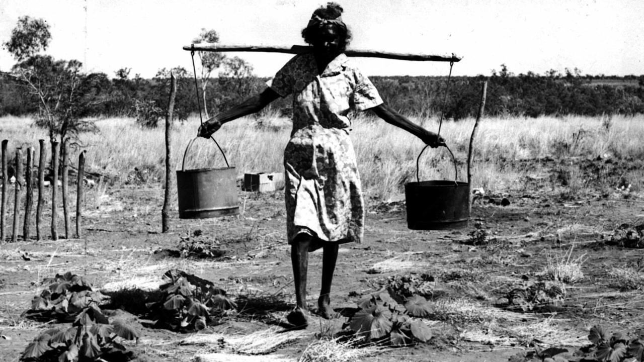 A Gurindji woman carrying water at the Wattie Creek settlement circa 1970. Picture: Northern Territory Photographic Services