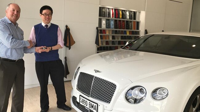 A salesman, left, hands Timothy Goh — the face of a campaign against tax reform — the keys to his Bentley. Picture: Facebook.