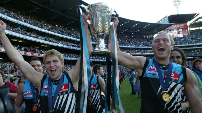 Kane (left) holds the 2004 premiership cup aloft with his brother, fellow Port player Chad.