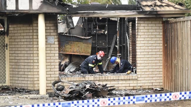 Fire investigators work through the remains of a house fire at 3 De Havilland Drive in Bray Park. Picture: Marcel Baum