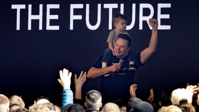 Tesla chief executive CEO Elon Musk carries on his shoulders his son X AE A-XII as he addresses employees during a visit at the company's electric car plant in Gruenheide, eastern Germany, in March. Picture: AFP