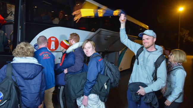 Crows fan Aaron Crosley waves his scarf before boarding the bus for Melbourne on Thursday night. Picture: Brenton Edwards.