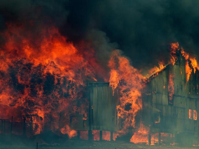 A wool shed catches fire near Carlton River on the Arthur Highway during the catastrophic bushfire in 2013. Picture: RICHARD JUPE