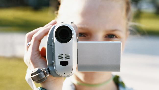 Generic pic of a young teenage girl filming on a digital camcorder.