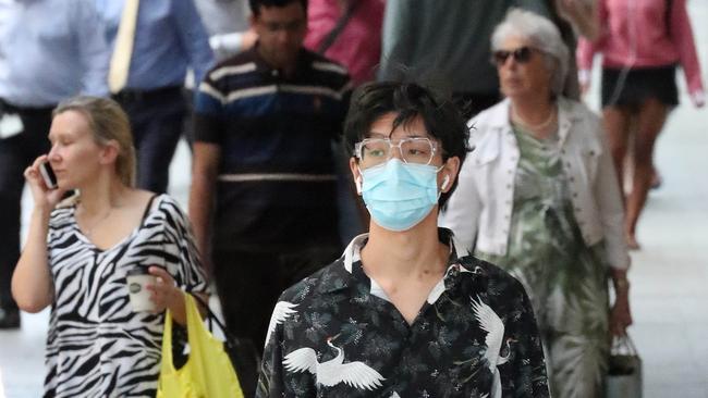 18 March 2018, A man with shopping and face mask, face masks being worn for Corona virus, Queen Street Mall, Brisbane. Photographer: Liam Kidston.