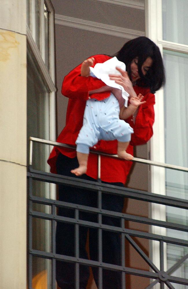 Jackson holds his eight-month-old son over the balcony of his hotel in Berlin. Picture: Olaf Selchow/Getty