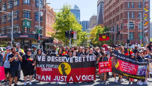 People hold a banner as they take part in the annual "Invasion Day" protest march through the streets of Sydney on Australia Day.