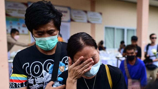 A woman cries after laying white roses on the steps of the childcare centre, where a former police officer killed at least 37 people in a mass shooting, in Thailand's northeastern Nong Bua Lam Phu province on Thursday. Picture: AFP