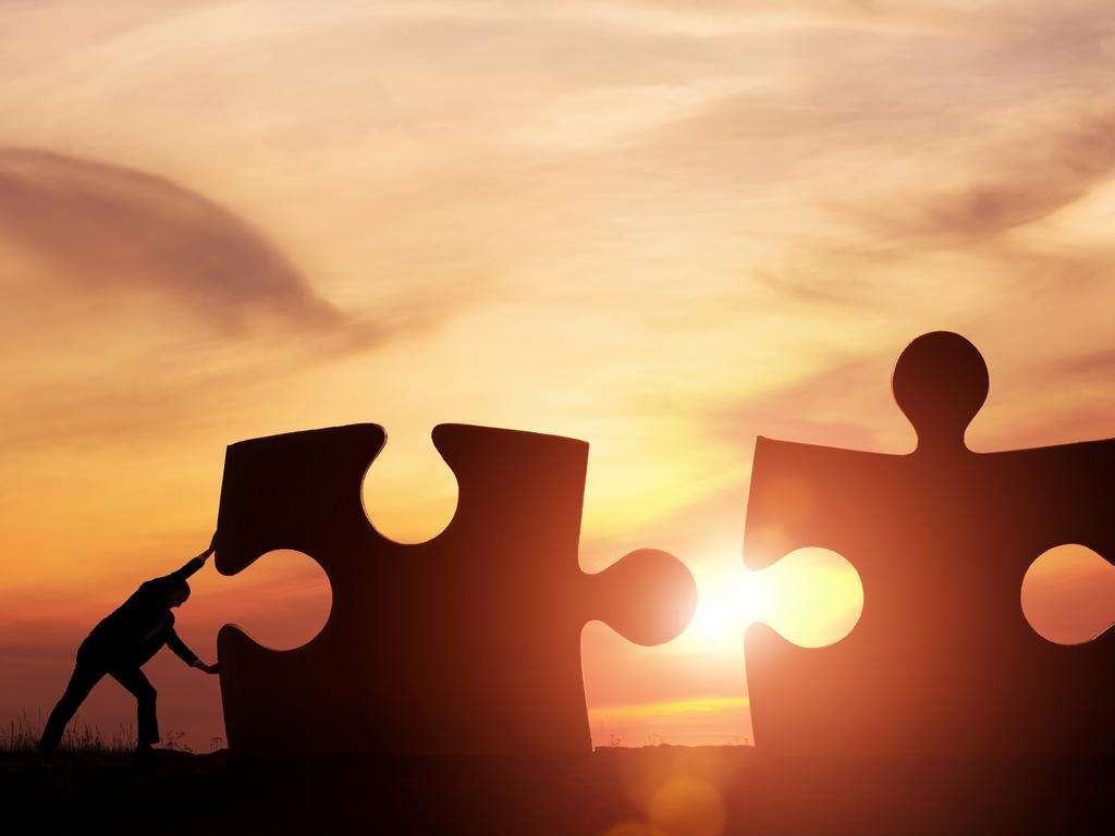 Two businessman connecting puzzle pieces togheter with copy space