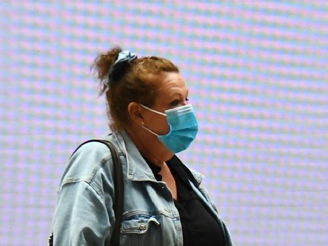 A woman passes a sign at Melbourne's Flinders Street station on September 17, 2020. - Australia's unemployment rate on September 17 fell slightly to 6.8 percent in August, spurring hopes that the worst of a coronavirus-fuelled recession may have passed. (Photo by William WEST / AFP)