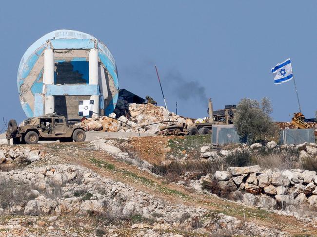 This picture taken from a position in northern Israel near the border with Lebanon, shows Israeli military vehicles in the southern Lebanese village of Marwahin on January 29, 2025. Israeli strikes wounded 24 people in south Lebanon on January 28 despite a ceasefire in force for more than six weeks, the Lebanese health ministry said. (Photo by Jalaa MAREY / AFP)