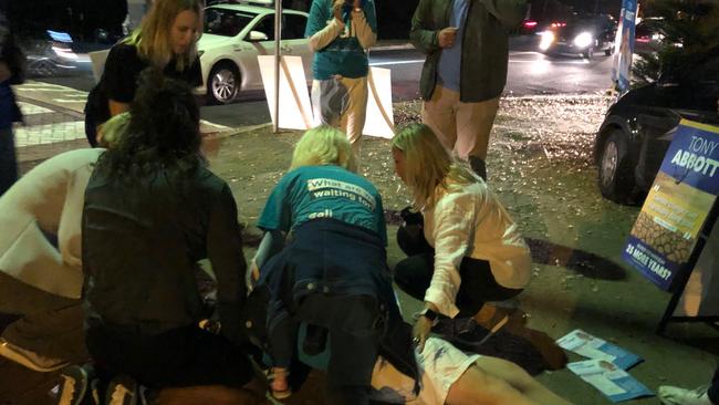 Zali Steggall (far left) attends to a supporter who collapsed shortly before 6pm. Picture: Julie Cross.