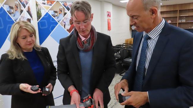 Minister for Corrections and Rehabilitation Madeleine Ogilvie, Community Corrections executive director Chris Carney and Attorney-General Guy Barnett inspect ankle bracelets at the Community Corrections Monitoring and Compliance Unit in Hobart on Thursday, February 6, 2025.