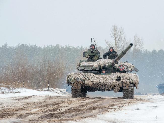 TOPSHOT - Ukrainian Military Forces servicemen of the 92nd mechanized brigade use tanks, self-propelled guns and other armored vehicles to conduct live-fire exercises near the town of Chuguev, in Kharkiv region, on February 10, 2022. - Russia's deployment for a military exercise in Belarus and on the borders of Ukraine marks a "dangerous moment" for European security, NATO's chief said on February 10, 2022. (Photo by Sergey BOBOK / AFP)