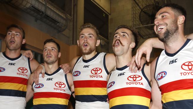 Rory Atkins, right, belts out the team song with Adelaide players on Saturday. Picture: Dylan Burns/AFL Photos