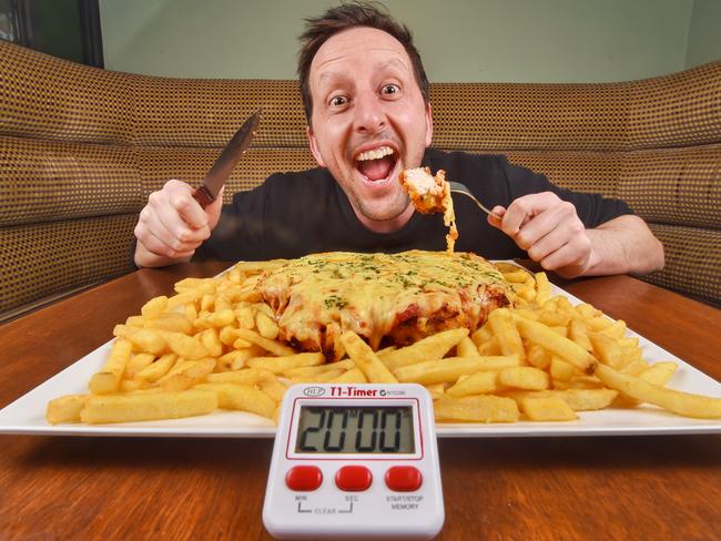 BEFORE: Herald Sun journalist Aaron Langmaid attempts to eat the giant parma named the Godfather at Irish Murphy's. Picture: Tony Gough