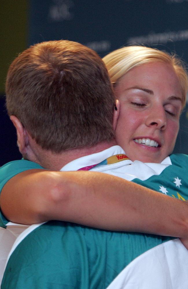 Sally Robbins shares a hug Australia’s chef de mission John Coates following a press conference at the 2004 Olympic Games.