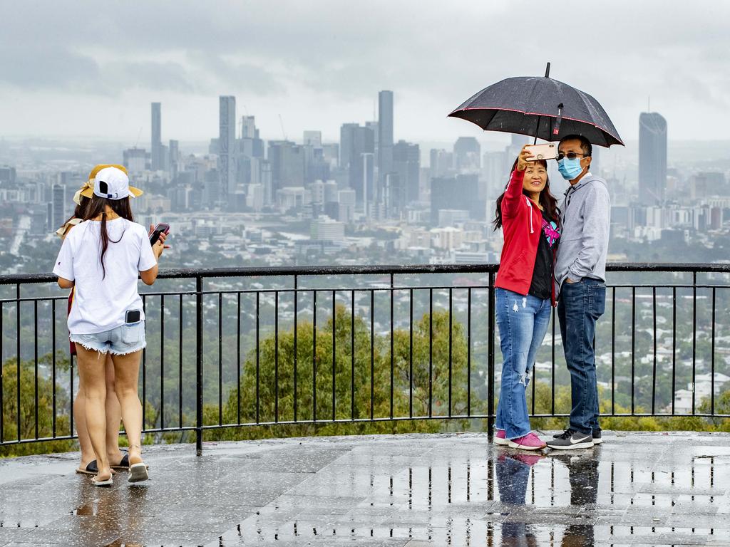 People braving the rain at Mt Coot-tha lookout, Saturday, January 1 as more wild weather is predicted to hit the southeast in coming days. Picture: Richard Walker