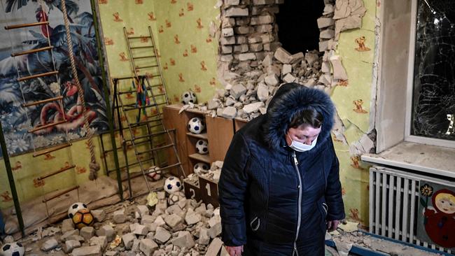 A woman stands among debris after the reported shelling of a kindergarten in the settlement of Stanytsia Luhanska, Ukraine Picture: AFP.