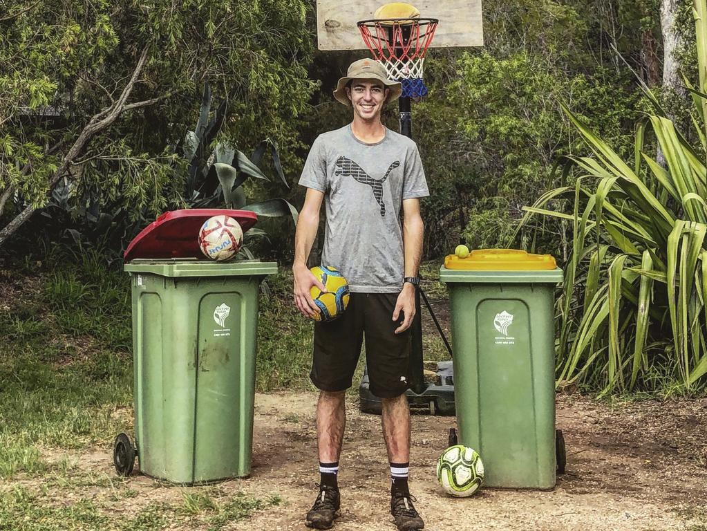 In this photo provided by Lucas Carberry, Jed Hockin poses in front of recycling cans and a basketball hoop in  Toowoomba, Queensland, Australia. Records are still being set even with many sports on hold during the coronavirus pandemic. There's a chance to be crowned worldÃ¢â¬â¢s best in categories such as most soccer touches with a roll of toilet paper in a 30-second span (winner: Jed Hockin with 84) or by simply putting on socks in a timely manner. (Lucas Carberry via AP)