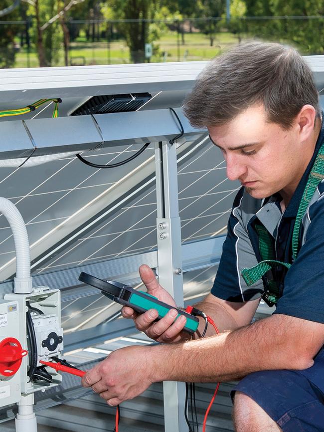 A Sharpe technician servicing and testing the electrics on a Solar PV System in 2017.