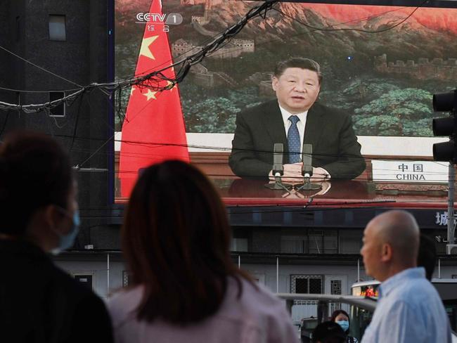 A news program shows Chinese President Xi Jinping speaking via video link to the World Health Assembly, on a giant screen beside a street in Beijing. Picture: AFP