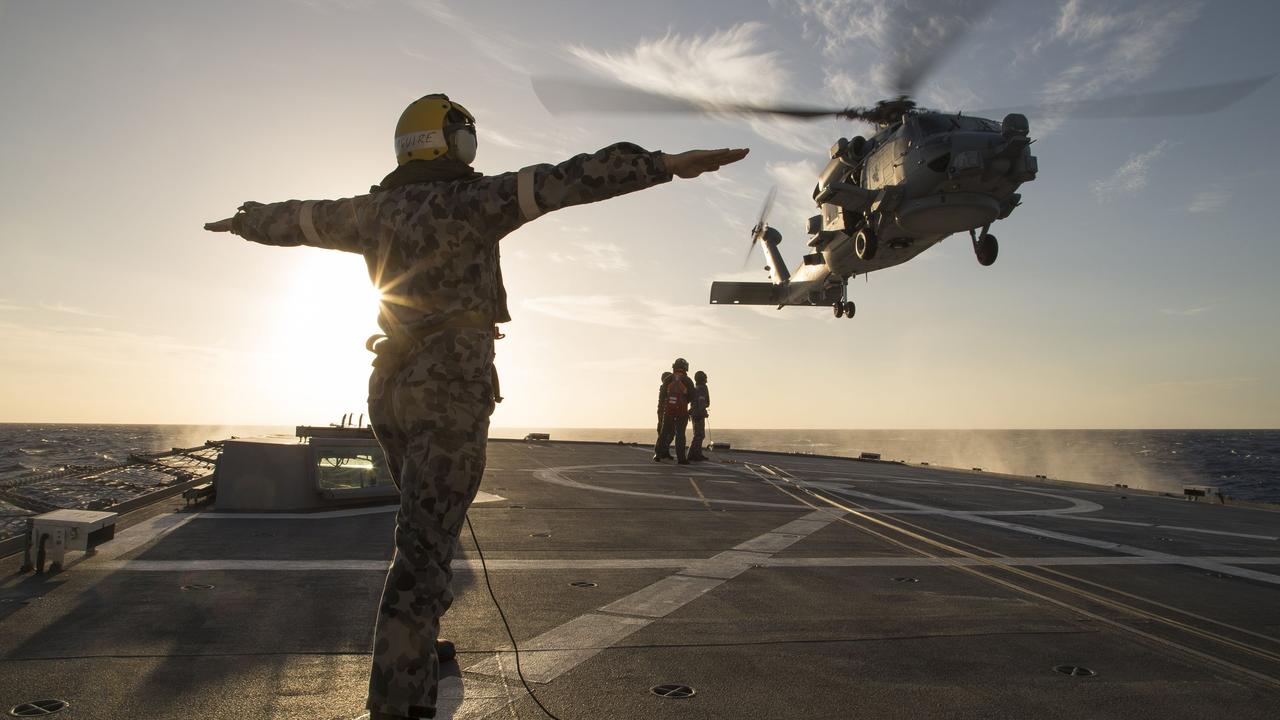 Leading Seaman Physical Trainer James Farquhar marshals the embarked MH-60R Seahawk over the flight deck of HMAS Parramatta during deck transfers. Picture: Defence