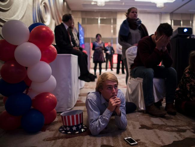 TOPSHOT - People react as they watch news on a screen to follow the results of the final day of the US presidential election at an event organised by the American consulate in Shanghai on November 9, 2016. US stock markets tumbled more than five percent in after-hours trading as Republican billionaire Donald Trump appeared poised to defeat Democratic rival Hillary Clinton in the race for the White House. / AFP PHOTO / JOHANNES EISELE