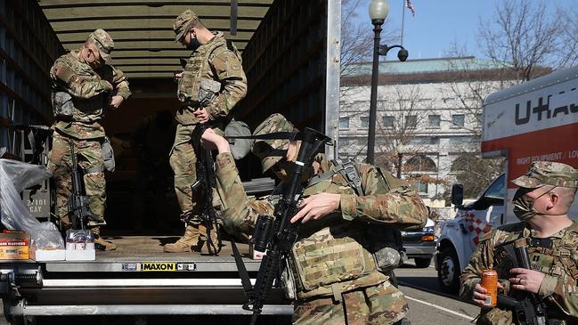 Members of the US. National Guard collect long guns from storage vehicles before beginning their shift protecting the US. Capitol ahead of the trial. Picture: Getty Images.