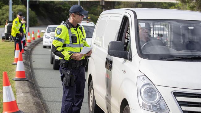 Police are seen directing cars from New South Wales that enter Queensland on the Gold Coast Photo: Glenn Hunt