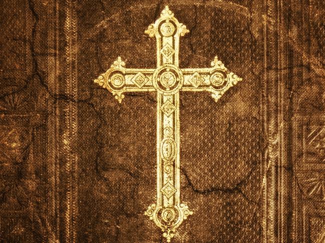 Close-up from cross of christ on an 100 years old Bible - Grunge Look. Istock