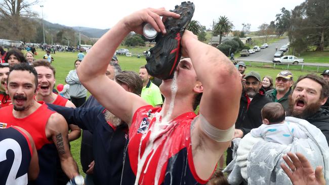 The taste of victory: Swifts Creek Demons celebrate winning the Omeo District FNL grand final at Buchan on Saturday. Picture Yuri Kouzmin