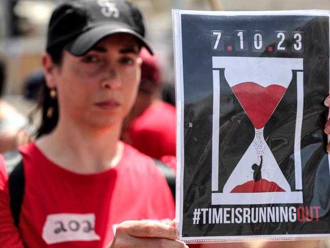 A woman holds a sign showing sand in an hourglass falling on a person during a protest by the relatives of Israeli hostages held in Gaza since the October 7 attacks. Picture: AFP