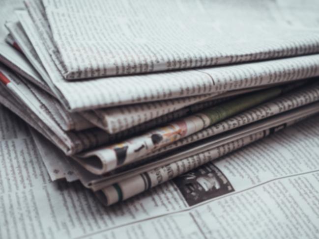 Pile of Daily newspaper on table,blur abstract background.