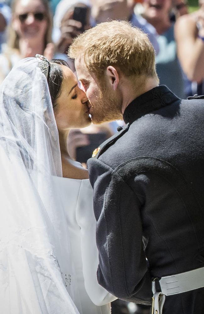 Prince Harry, the Duke of Sussex, kisses his bride and The Duchess of Sussex kiss on the steps of St George's Chapel in Windsor Castle. Picture: Getty